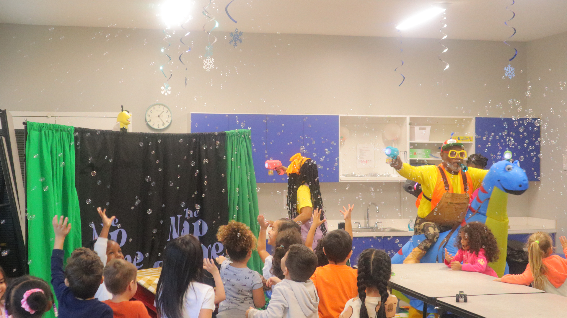Children reaching up to catch bubbles during the performance