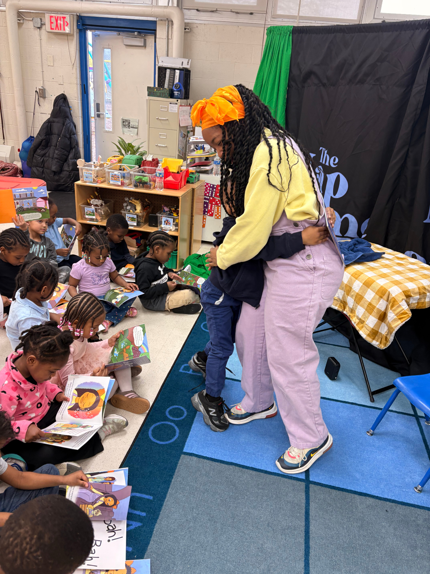 Performer hugging a child during a classroom storytime visit