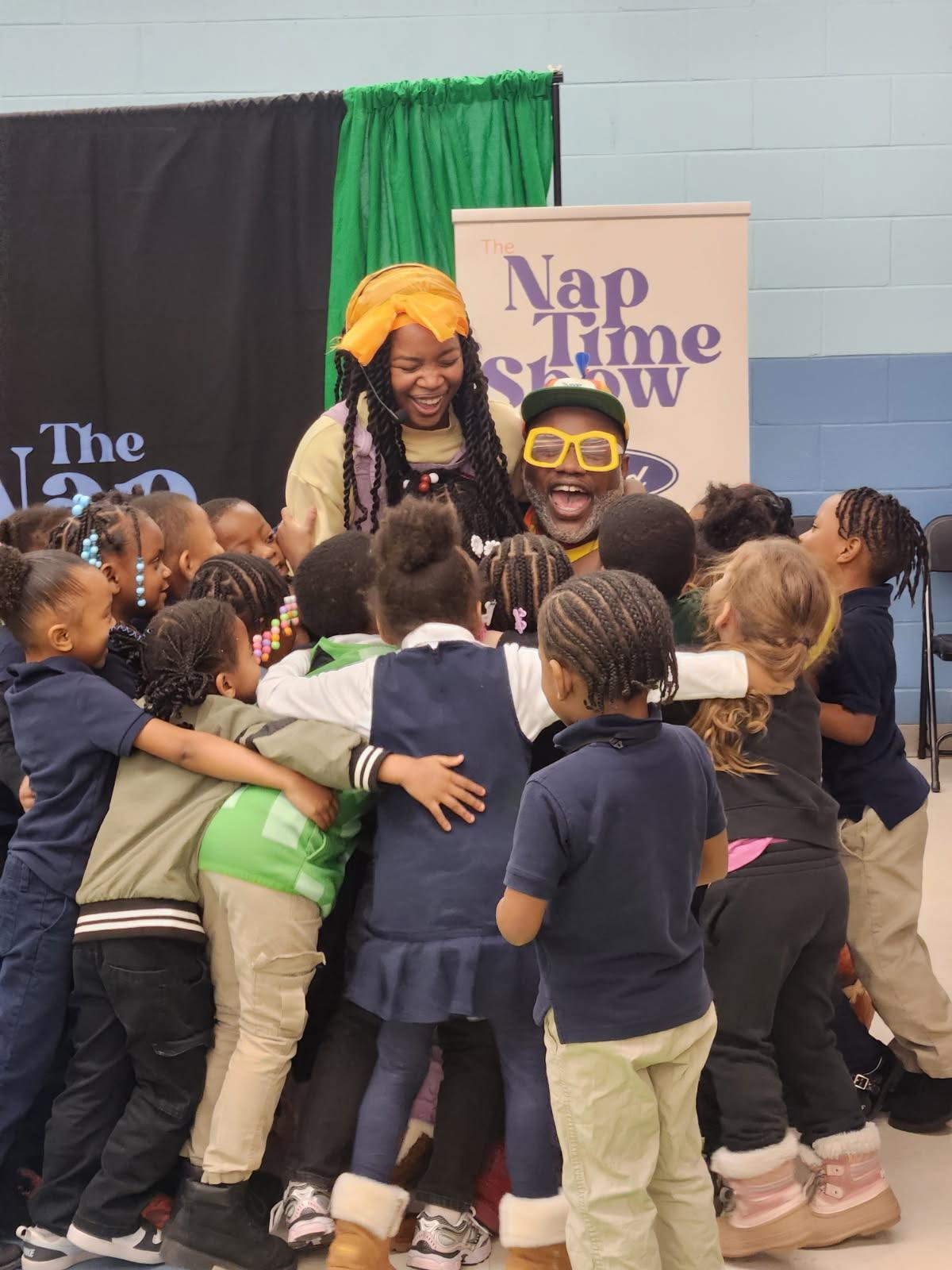 A group of children hugging the performers after a show